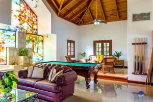 拉罗马纳Luxury Villa Casa De Campo的客厅设有台球桌和彩色玻璃窗。
