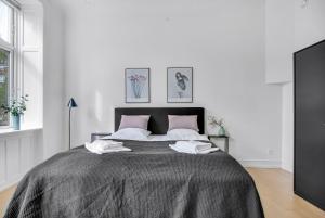 哥本哈根City Square Hotel Apartments的白色卧室配有带粉红色枕头的大床