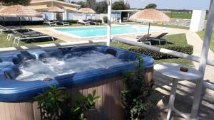 奥特朗托Case vacanza Gli Oleandri的游泳池旁的蓝色浴缸