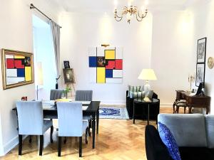 华沙Luxury Suites & Apartments MONDRIAN Market Square II的用餐室以及带桌椅的起居室。