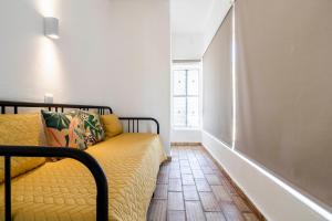 塔维拉Apartamento 157, Pedras d’el Rei的窗户房间里一张黄色的沙发