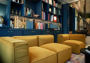 巴黎Hôtel Amoi Paris的客厅配有两把椅子和一张沙发