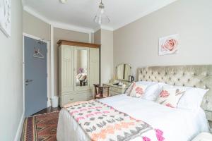 伦敦House close to kings cross的卧室配有白色床和粉色及白色毯子