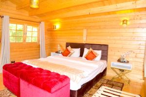 内罗毕Severine Cottages and Lounge Ltd的一间卧室配有一张大床和一张红色的沙发