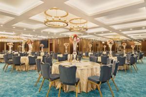伊斯坦布尔Days Hotel by Wyndham Istanbul Maltepe的宴会厅配有桌椅和吊灯