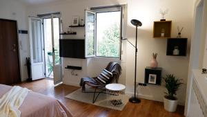 拉韦纳蓬泰特雷萨Lavena - LAKE & MOUNTAIN Apartments的一间卧室配有椅子、床和窗户