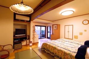 箱根马斯托米旅馆的一间带大床和电视的卧室