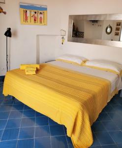 伊斯基亚Agata Suite的床上有黄色的毯子