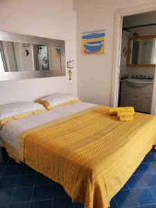 伊斯基亚Agata Suite的一间卧室配有一张大床,床上有黄色的毯子