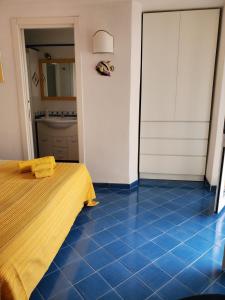 伊斯基亚Agata Suite的卧室铺有蓝色瓷砖地板,配有1张床