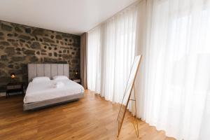 蓬塔德尔加达CITY STONE HOUSE的一间卧室设有一张床和石墙