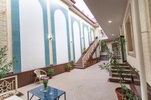 撒马尔罕Registon Saroy Hotel的走廊上设有楼梯和盆栽植物