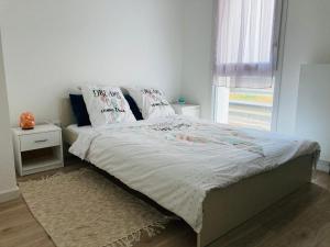 梅斯Appartement Muse proche Gare的卧室内的一张带白色床单和枕头的床