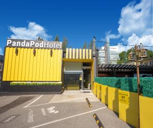 里士满Panda Pod Hotel的黄色的建筑,上面有标志