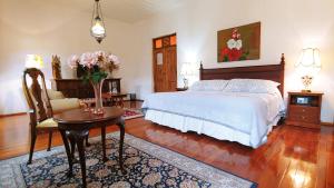 昆卡Casa Montalvo Bed & Breakfast的卧室配有1张床、1张桌子和1把椅子