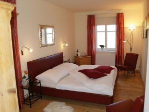 Gobelsburg科班肖夫农家乐的一间卧室配有白色床单和红色窗帘