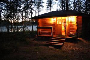 NyröläMökki Jyväskylä的树林中灯火通明的小小木屋
