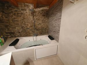 DurroCasa Garrabet的带浴缸的浴室和石墙