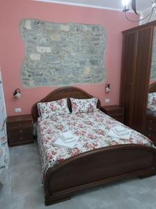 维拉皮亚纳La casetta di nonna Maria的一间卧室配有一张带花卉床罩的床