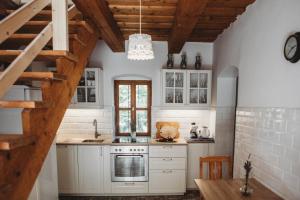 VászolyAndante Vendégház的厨房配有白色橱柜和木制天花板