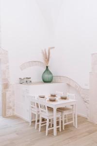 莫尔费塔INDE Á LA TERRE, GUEST HOUSE Locazione Turistica的白色的厨房配有白色的桌子和椅子
