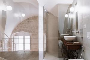莫尔费塔INDE Á LA TERRE, GUEST HOUSE Locazione Turistica的两张带水槽和淋浴的浴室的图片