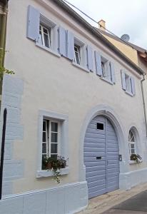 葡萄酒之路上的诺伊施塔特Alte Schmiede Neustadt的白色的房子,设有车库门和窗户