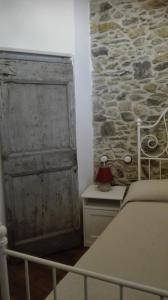 NasinoAgriturismo Nonnamelia的一间卧室设有一张床和石墙