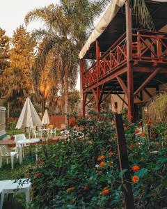 圣佩德罗Hotel Los Pinares的花园设有桌椅和鲜花