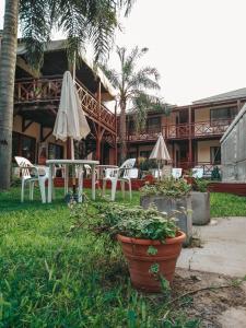 圣佩德罗Hotel Los Pinares的庭院配有桌椅和遮阳伞。