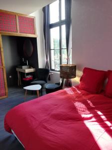 Combles-en-BarroisGite - COTE GREEN的卧室设有红色大床和窗户。