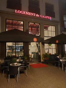 阿默斯福特Hotel de Gaaper的一间带桌椅和遮阳伞的餐厅