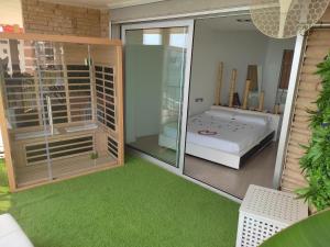 迈阿密普拉特亚Exclusivo Apartamento Spa privado frente el mar的一间设有床铺的房间和一间铺有绿色地毯的房间