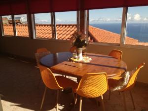 丰沙尔The Hill View House的餐桌和椅子,享有海景