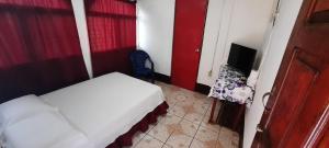 玉米岛Tropical Dreams Hostel的一间小卧室,配有一张床和电视