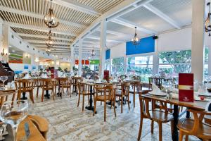 基兹洛特Crystal Admiral Resort Suites & Spa - Ultimate All Inclusive的餐厅设有木桌、椅子和窗户。