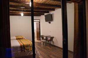 Nuevo TingoUtcubamba River Lodge的客房设有一张床和一张桌子及一台电视