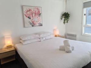 荷斯安山Red Robin的一间卧室配有一张带两盏灯的大型白色床。