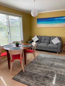 AlonnahBruny Ocean Cottage的客厅配有桌椅和沙发