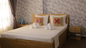 撒马尔罕Samarkand Сity Guest House的卧室配有一张带白色床单和枕头的大床。