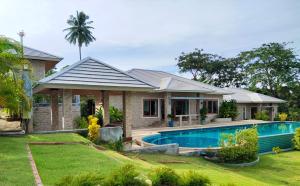 波普托Baan Nai Daeng Villa /Baannaidaengvilla的庭院中带游泳池的房子