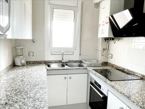 埃勒凡达尔Open Sky, Apartamento con solárium privado y barbacoa的白色的厨房设有水槽和窗户