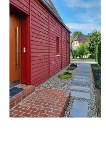博恩Ferienwohnung Rote Kate的一座红楼,旁边是砖砌的走道