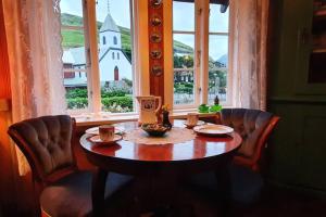 KvívíkCharming and Authentic Heritage Retreat in Kvívík - right next to the river的窗户客房内的桌椅