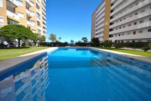 福恩吉罗拉Fuengirola Los Boliches Ronda 3 VISTAS AL MAR Paseo Maritimo At the Promenade with Sea Views的一座大型游泳池,位于部分建筑前