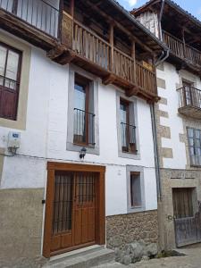 坎德拉里奥Apartamento La Herrerita的一座带木门和阳台的房子
