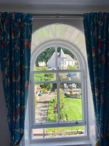 克里夫Leven House Bed and Breakfast的享有房屋景致的拱形窗户