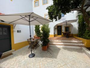 埃武拉Casa Teresa的一个带桌子和遮阳伞的庭院