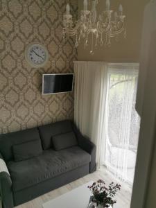 科尔卡Sapņi的客厅配有沙发和墙上的时钟