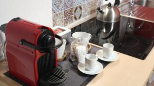 贝加莫Domus Solarii Holiday Home的红色咖啡壶,坐在带杯子的柜台上